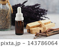 Amber glass dropper bottle with lavender, dried herbs, and cinnamon sticks 143786064