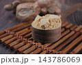 Ground cinnamon powder in a wooden cup with cinnamon sticks 143786069