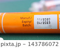 Orange insulin syringe barrel showing manufacturing, expiry, and batch label 143786072