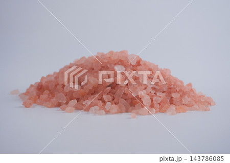 Pink salt crystals piled on a surface in a studio setting 143786085