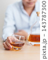 man with glass of cognac on table, suffering from alcohol addiction and alcoholism concept. depicting emotional distress, depression, substance abuse problem, unhealthy lifestyle and mental health 143787300