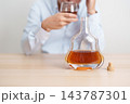 Stressed man drinking cognac alone with problem. Exhausted drunk man looking stressed and sleepy. Alcohol addiction, Alcoholism, emotional distress and mental health concept 143787301