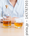 man with glass of whiskey on table, suffering from alcohol addiction and alcoholism concept. depicting emotional distress, depression, substance abuse problem, unhealthy lifestyle and mental health 143787303