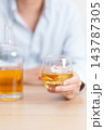 man with glass of whiskey on table, suffering from alcohol addiction and alcoholism concept. depicting emotional distress, depression, substance abuse problem, unhealthy lifestyle and mental health 143787305