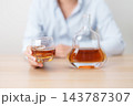man with glass of cognac on table, suffering from alcohol addiction and alcoholism concept. depicting emotional distress, depression, substance abuse problem, unhealthy lifestyle and mental health 143787307