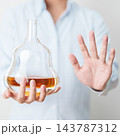 Man making stop hand gesture to refuse a bottle of Cognac, Healthy man say no to alcohol drink, stop alcoholism and addiction concept. Responsible man reject a drink before driving and quit booze 143787312