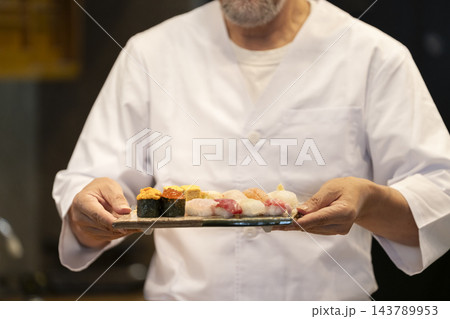 角皿に盛られたお寿司を持つ鮨職人 角皿に盛られたお寿司を持つ鮨職人 143789953