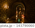Halloween brick tunnel with glowing jack o lantern pumpkins, burning torches, candles, skulls and skeleton, 3D illustration of a spooky underground dungeon 143790060