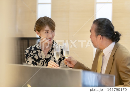 和食店のカウンター席で乾杯するシニア夫婦 和食店のカウンター席で乾杯するシニア夫婦 143790170