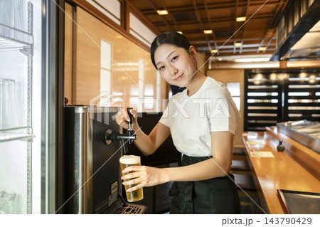 サーバで生ビールを注ぐ飲食店の若い女性スタッフ　カメラ目線 143790429