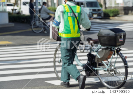 交差点を渡る駐車監視員の後ろ姿 交差点を渡る駐車監視員の後ろ姿 143790590
