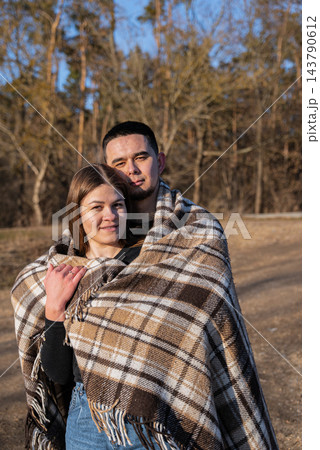 Young Couple Embracing Under Blanket During Winter Road Trip 143790612