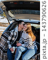 Young Couple Embracing Under Blanket During Winter Road Trip 143790626