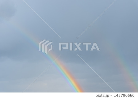 Weather conditions light interaction and beauty of nature. Soft daylight illuminates the clouds and enhances the vivid rainbow arc. Concept of hope optimism tranquility meteorology climate, and 143790660