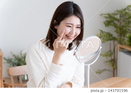 鏡で肌のチェックをするミドル女性 143791596