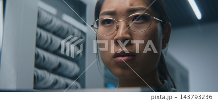 Female IT Specialist Reviewing Technical Data on Digital Tablet in Modern Server Room 143793236