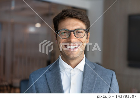 Headshot portrait of smiling Latino businessman in formal suit 143793307