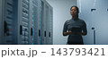 Network Engineer Examining Structured Patch Cables and Reviewing Technical Data on Tablet 143793421