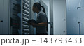 Network Engineer Examining Structured Patch Cables and Reviewing Technical Data on Tablet 143793433