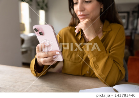 Adult woman checking smartphone, reading messages, using mobile application Adult woman checking smartphone, reading messages, using mobile application 143793440