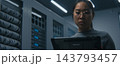 Young Female IT Specialist Reviews Technical Data on Tablet in Modern Server Room. 143793457