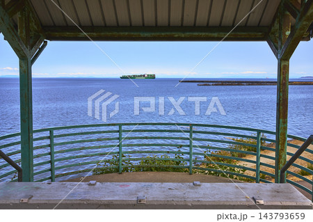 Waterfront Lookout Structure and Container Ship on Blue Bay in Port Angeles Washington 143793659