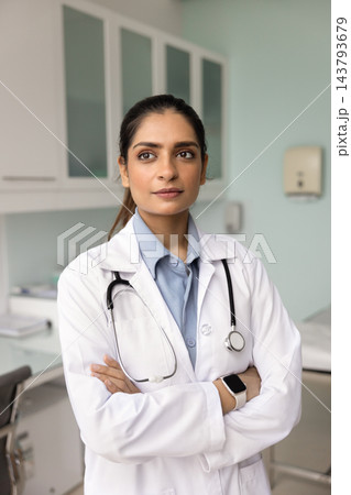 Thoughtful Indian therapist dressed in uniform standing in clinic office Thoughtful Indian therapist dressed in uniform standing in clinic office 143793679