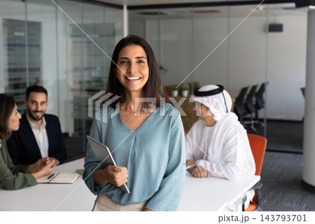 Smiling Latina businesswoman holding digital tablet, looking at camera 143793701