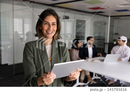 Latina businesswoman using digital tablet standing in conference room, portrait Latina businesswoman using digital tablet standing in conference room, portrait 143793816
