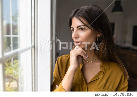 Woman standing next to window, thinking, looking outside Woman standing next to window, thinking, looking outside 143793836