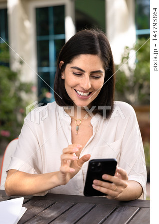 Beautiful woman using smartphone in sunny garden 143793864