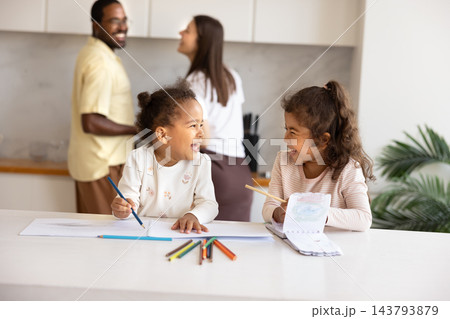 Children drawing pictures with colored pencils sit at kitchen table Children drawing pictures with colored pencils sit at kitchen table 143793879