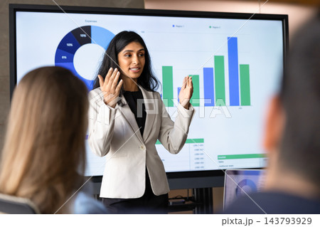 Female makes presentation, discussing financial charts, explaining statistics on screen 143793929