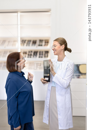 Female optometrist consulting senior woman in optical clinic 143793931