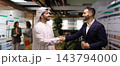 Banner of multicultural businessmen shaking hands in office corridor 143794000