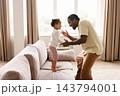 Black father playing with toddler daughter at home 143794001
