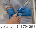 Podiatrist treats patient toenail using professional electric milling cutter in clinic room. Careful specialist holding precision podiatry drill performs hygienic foot care. 143794299