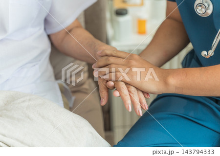 Healthcare worker comforting senior patient in home care setting. 143794333