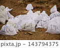 Marathon drop-bags on dirt trail at Sierra Cazorla, Quesada-Jaen, Andalusia - numbered kit sacks for long-distance race 143794375