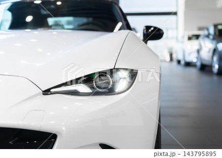 front view of new modern white sports car led headlight in showroom front view of new modern white sports car led headlight in showroom 143795895