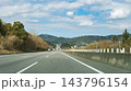 青空の下に伸びる高速道路の直線道路と山並みの風車風景 143796154
