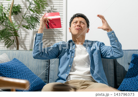 通帳を見て嘆く男性 通帳を見て嘆く男性 143796373