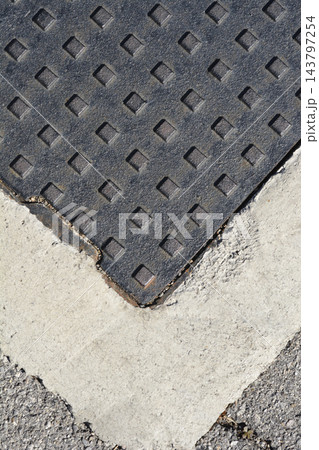 Top view of a cast iron manhole cover in concrete frame 143797254