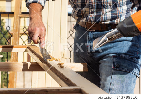Carpenter at work, restoring an old wooden window. Carpentry. Carpenter at work, restoring an old wooden window. Carpentry. 143798510