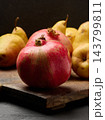 Ripe red pomegranates and yellow pears on a wooden board 143799811