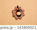 Cosmetic dropper bottle with a blank label on a woven stand, top view 143800021