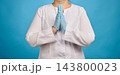 Doctor in a white coat and blue medical gloves holding hands in a praying or pleading gesture, medic hoping for recovery 143800023