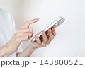 スマホを使う女性の手元　SNSイメージ 143800521