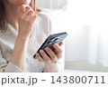 スマホを見て悩む女性 143800711