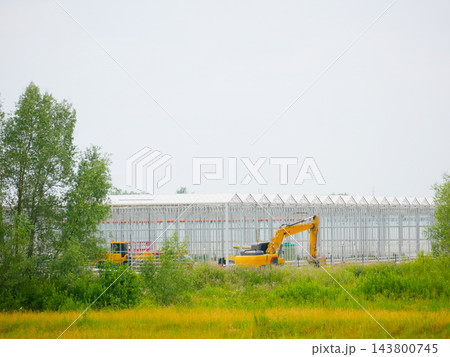 Large Greenhouse Structure Construction With Yellow Excavator Large Greenhouse Structure Construction With Yellow Excavator 143800745